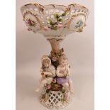 Meissen style pedastal comport with 4 cherubs seated around a tree. It has had a repair to the