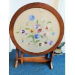 Pretty small round table with needlepoint decoration of Pansies under glass top. Top folds down to