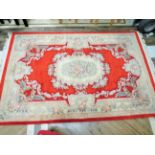 Stunning Crimson based fringed woolen rug with floral decoration which measures 116 x 72 inches in g