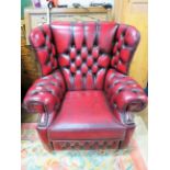 Chesterfield wing back armchair, beautifully upholstered in Oxblood leather. Excellent condition..