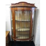 Bow fronted glass display cabinet with leaded glass to door and sides. Raised on cabriole legs it me