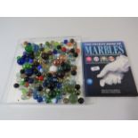 Selection of vintage marbles and a marbles book.