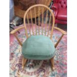 Blondwood stick back rocking chair with barrel turned legs and supports. In the Ercol style but no m