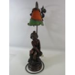 Figural lamp of a child sat on a wall, approx 22.5" tall.