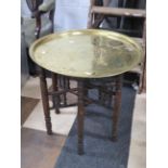 Folding eastern table with carved supports and decorated brass top.. H:21 x Diameter 23 Inches. See
