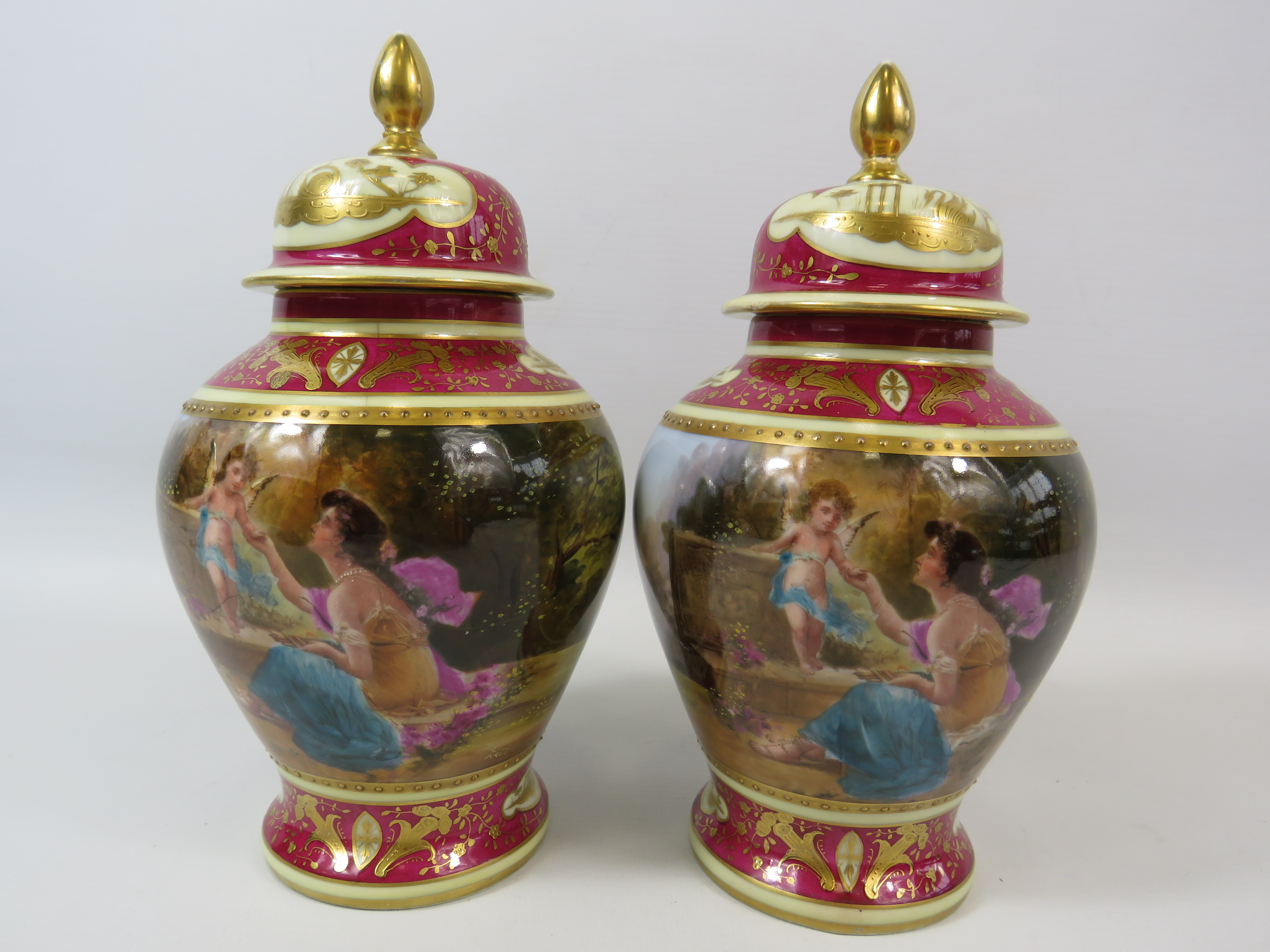 Pair of Vienna style lidded urn vases, both have had a repair/ damage to the lids. Approx 9" tall.