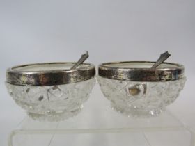 2 Victorian glass salts with sterling silver rims and 2 silver plated salt spoons.