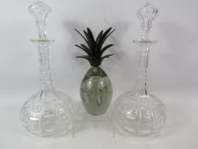 Pair of matching crystal decanters and a pineapple paperweight.
