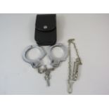 Pair of hand cuffs with pouch plus a AM whistle.