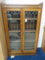 Early 20th Century Oak bookcase with leaded glass doors. Three adjustable wooden shelves within. Wi