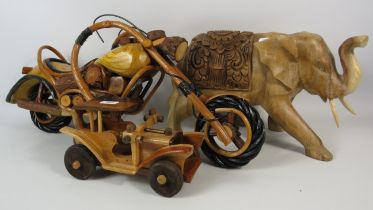 Carved wooden elephant, handmade wooden motorbike and car. The motorbike measures 9" tall and 20"