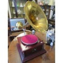 Replica of a vintage HMV wind up turntable in working order with large brass trumpet shaped speaker.