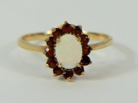 9ct Yellow Gold ring set with a central Opal surrounded by Garnets. Finger size 'P-5' 1.3g