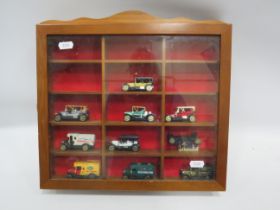 10 small cars in a display case.