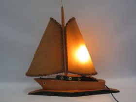 Vintage wooden boat table lamp with Hide sails, in working condition 20" tall and 20" long. It would