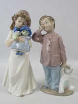 2 Nao Lladro figurines, a girl with a doll and a boy with a teddy the tallest measures 8".