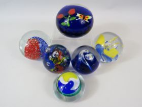 6 Blue, red, yellow coloured paperweights.