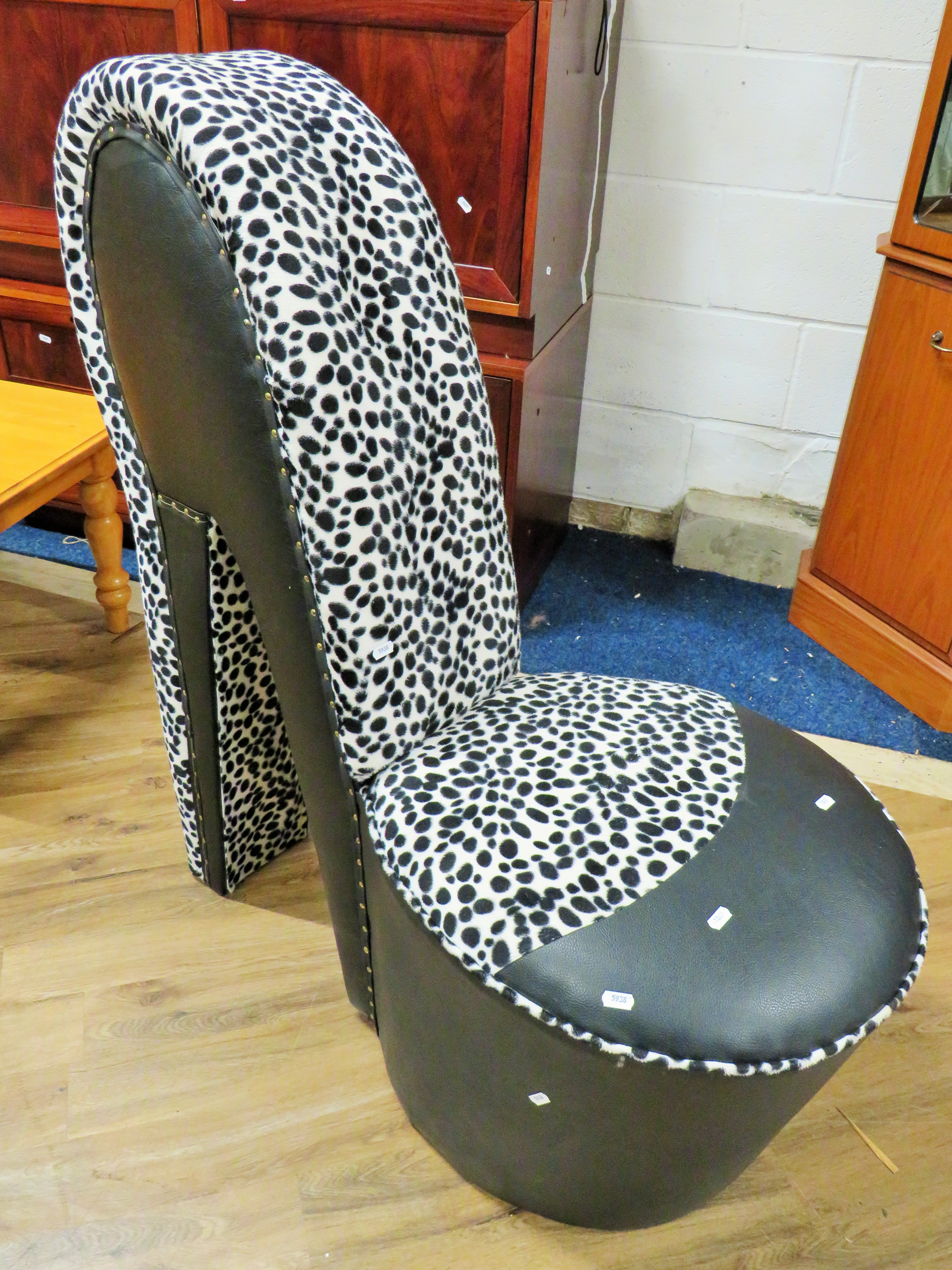 Bedroom chair shaped as a ladies shoe.  Finished in leatherette and animal print fabric. Measures H: