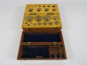 Boxed set of metric brass weights (smallest weight missing) plus a small empty box.