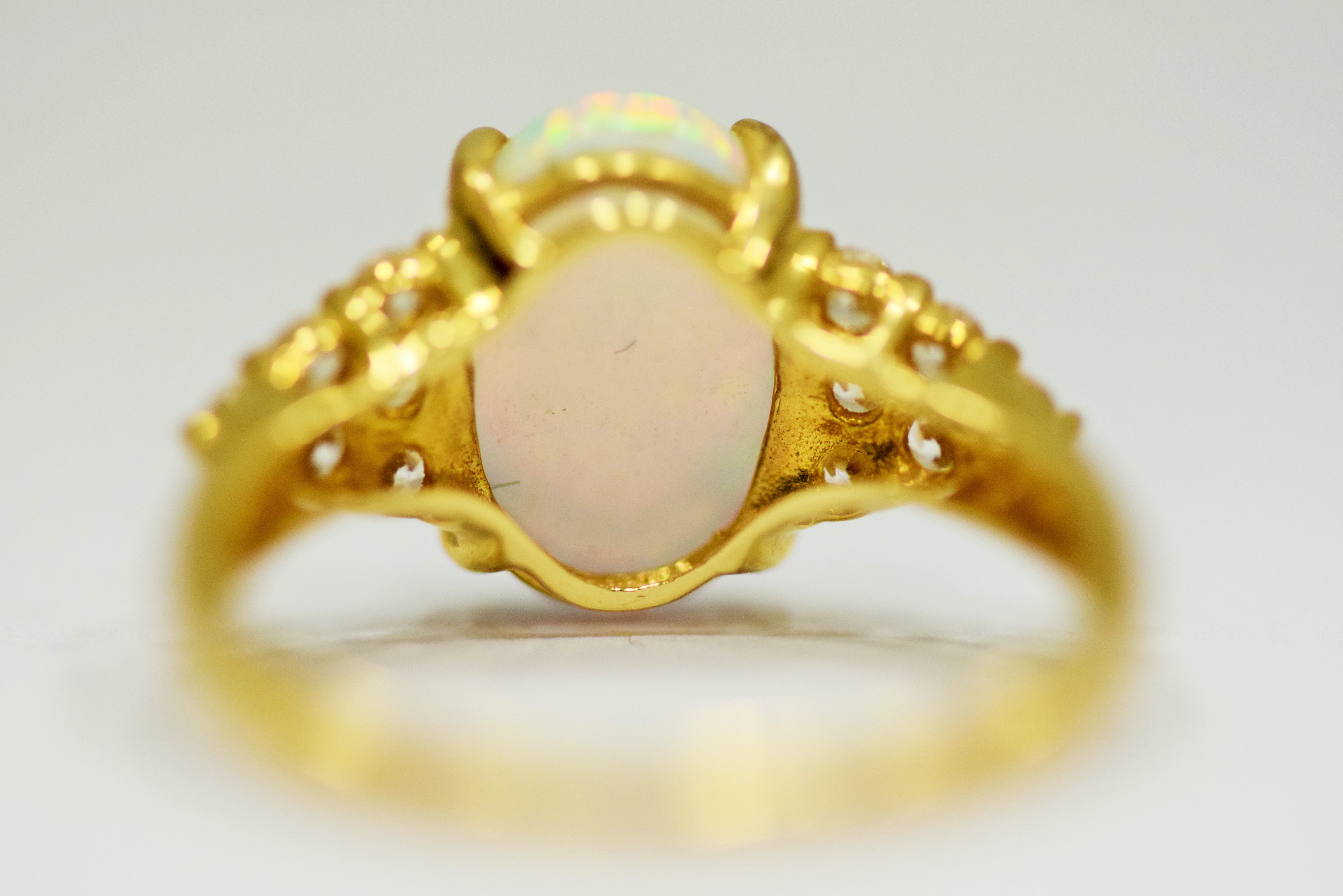 14ct Yellow Gold Ring set with a large central Opal which measures 12 x 8mm with 12 clear gemstones  - Image 4 of 4
