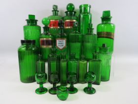 Large selection of vintage emerald green medical bottles and eye wash baths.