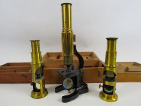 3 Vintage brass medical microscopes in wooden cases.