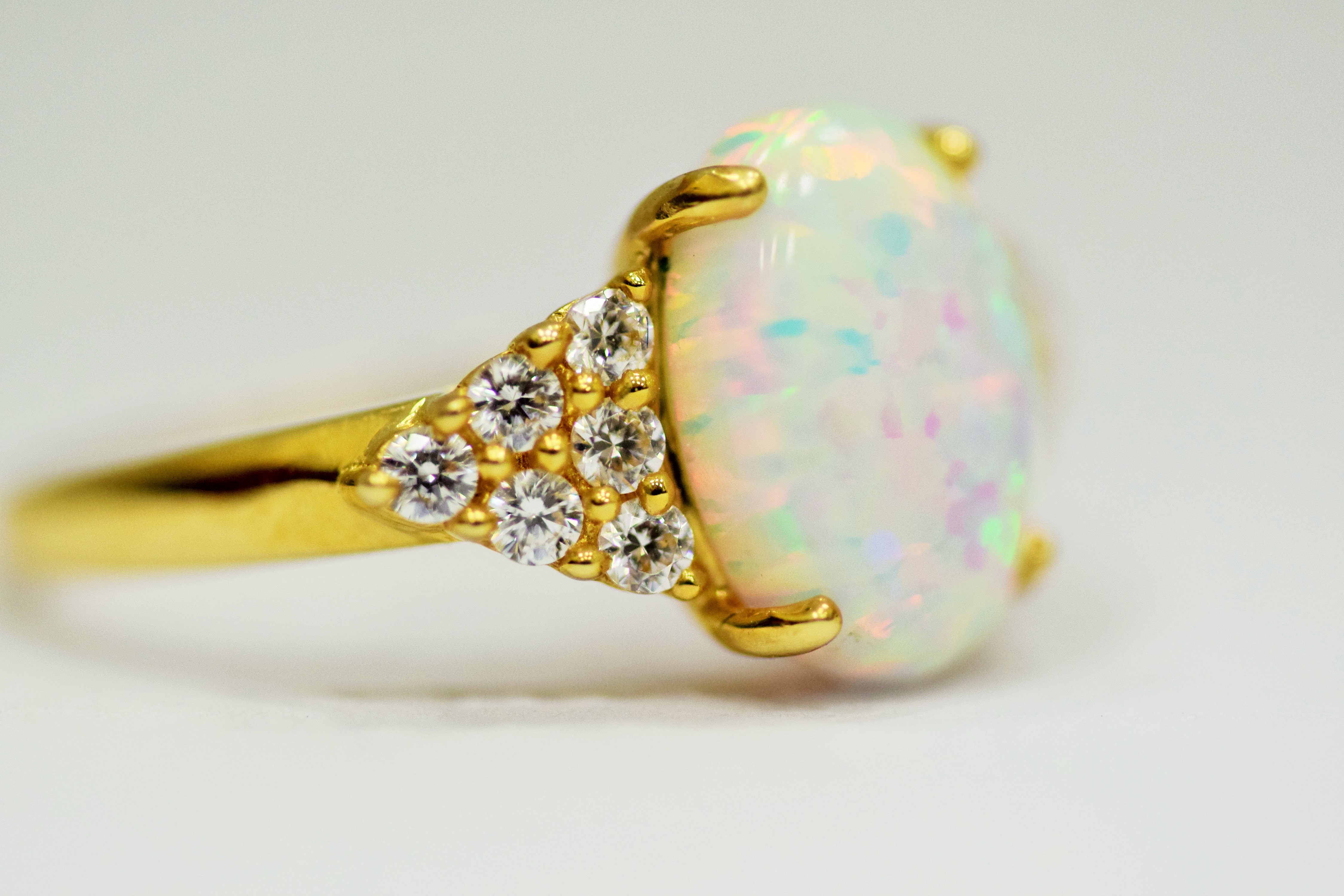14ct Yellow Gold Ring set with a large central Opal which measures 12 x 8mm with 12 clear gemstones  - Image 2 of 4
