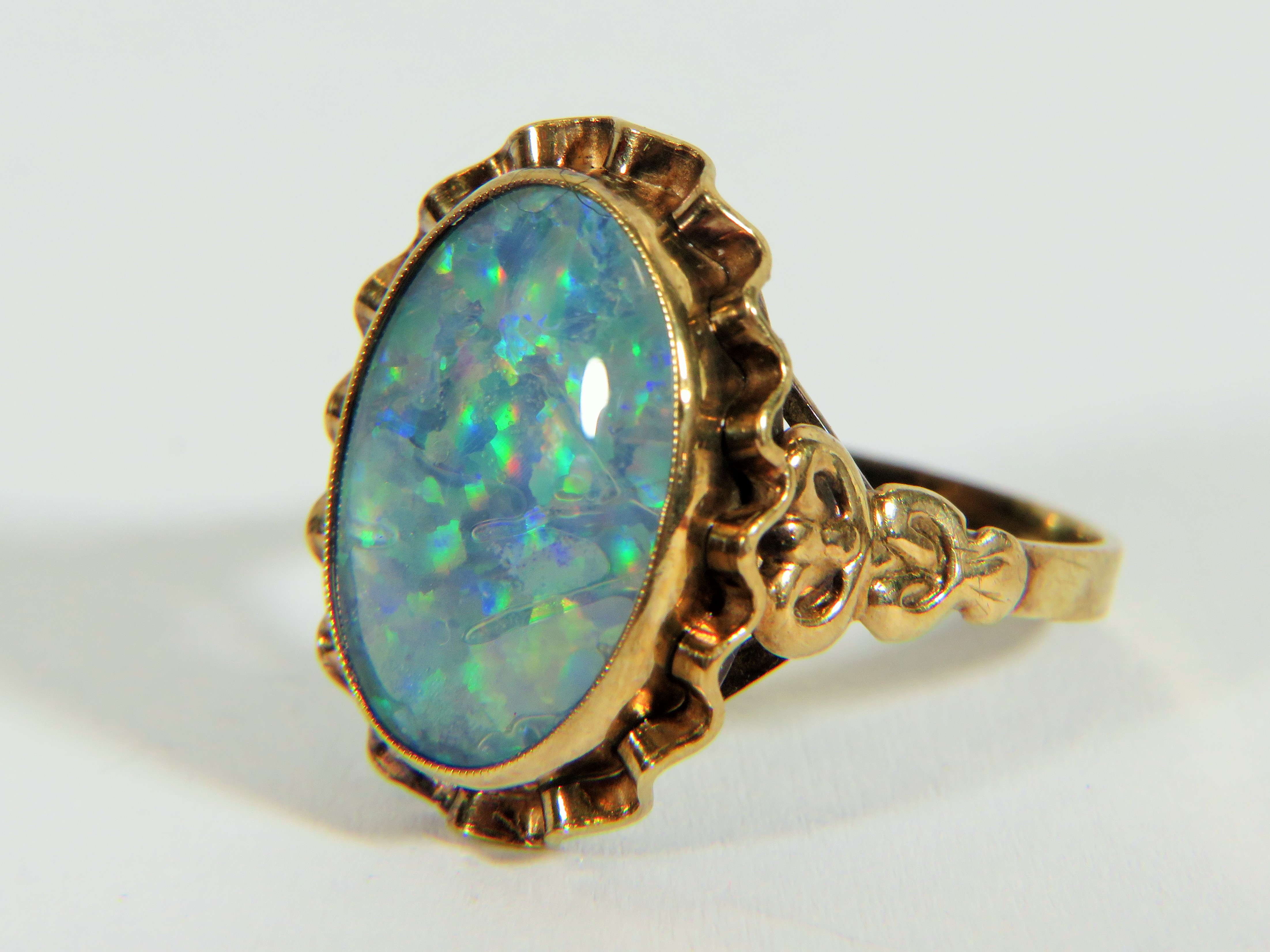 Yellow metal ring (testing 9ct) set with large reconstitued Opal which measures 20 x 14 mm  Finger s