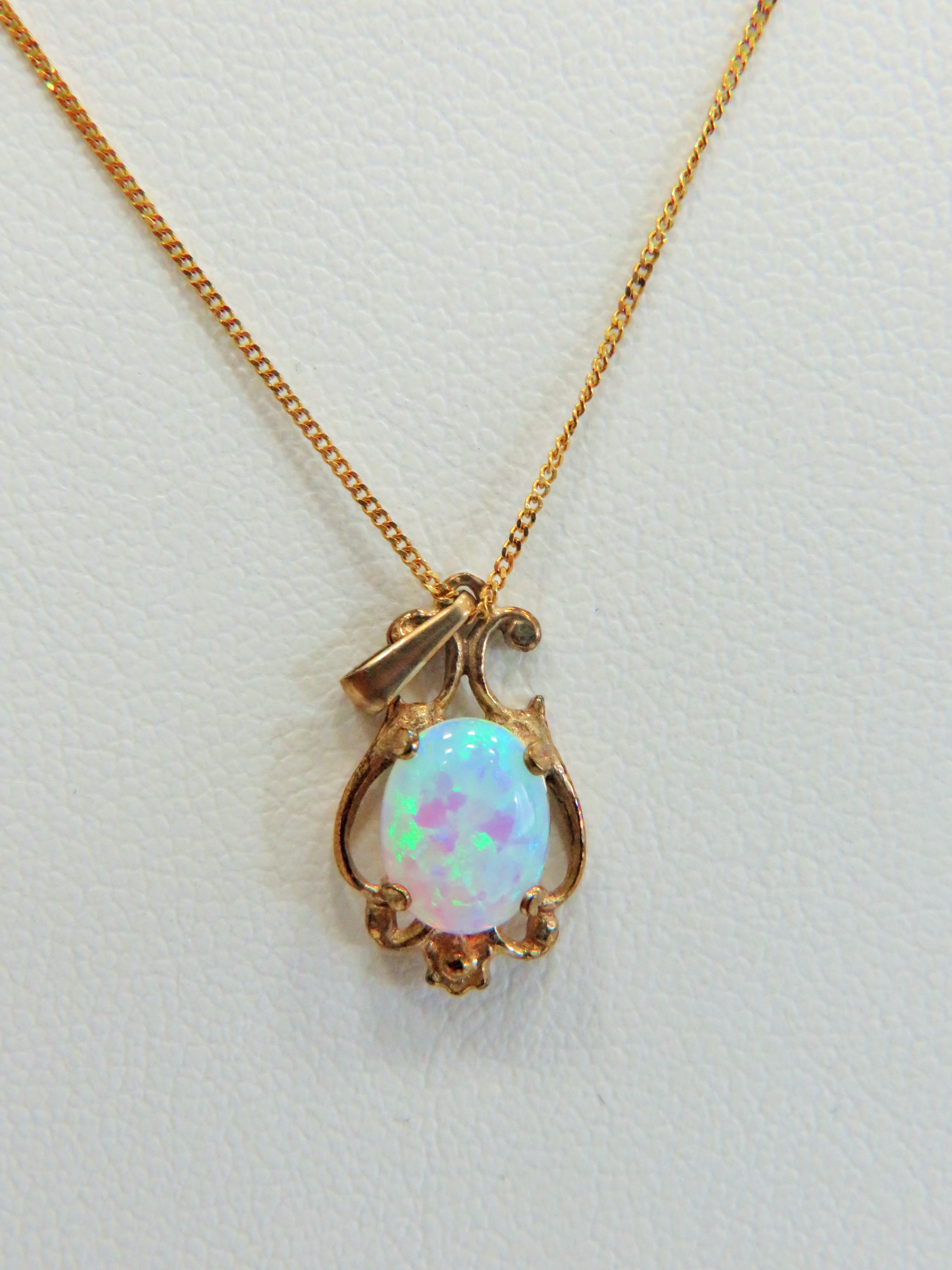 9ct Gold Art Nouveau style pendant set with a high coloured Opal hung on an 18 inch 9ct Chain.  Tota