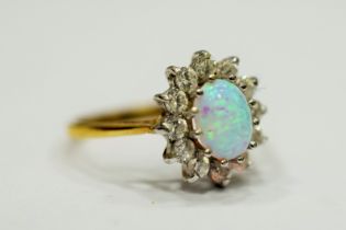 9ct Yellow Gold ring set with a lovely Central Opal which measures 8 x 5mm, surrounded by Clear gems