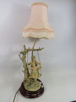 B Merli Italian figural lamp of children on a swing, 21 " to the top of the light fitting and