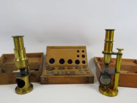 2 Small brass medical microscopes and a set of apothecary weights.