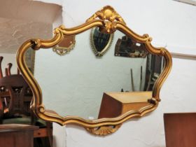 Ornate mirror with modern composite gilt frame in the antique style. Measures approx 34 x 27 inches.