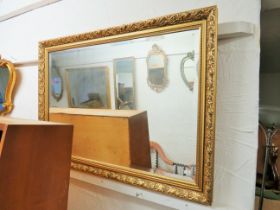 Bevelled glass mirror with gilt effect composite frame which measures approx 39 x 28 inches. See pho
