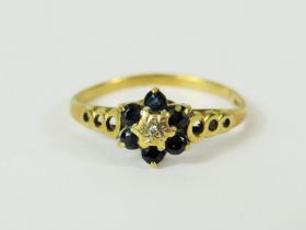 9ct Yellow Gold ring set with a small central Diamond and surrounded by six small Sapphires. Ring