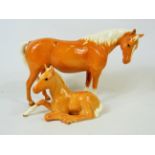Beswick Palamino Mare facing Right along with a Beswick Palamino lying down foal (915). Both in exc