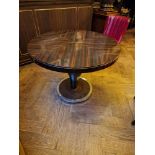 A flamed mahogany circular dining table mounted on a baluster pedestal on circular base with