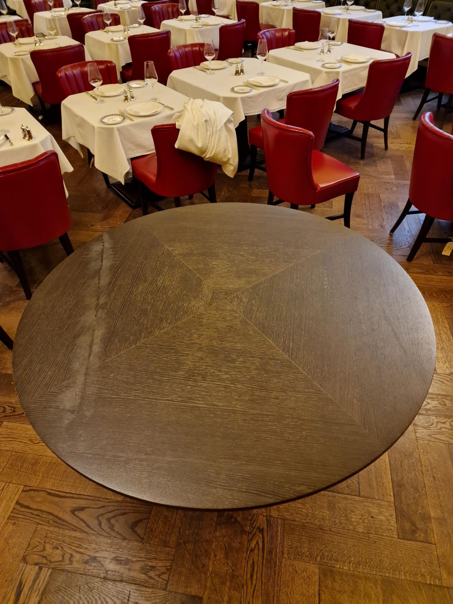 A bespoke Robert Angell Churchill circular dining table the oak top mounted above a shaped square