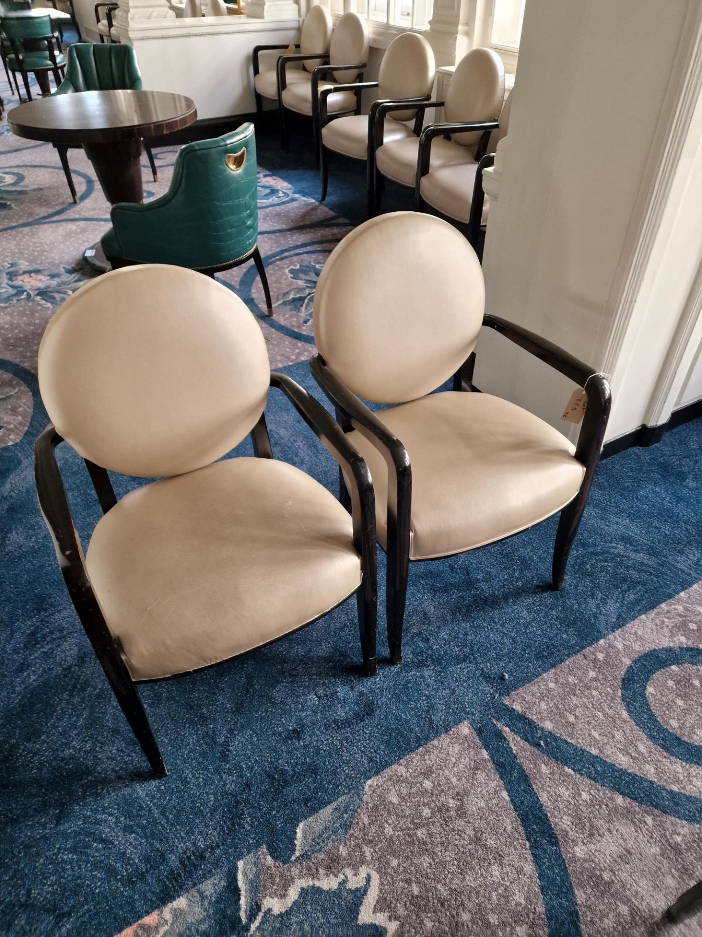 A pair of French style round back armchairs upholstered in champagne gold leather the round back