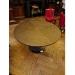 A bespoke Robert Angell Churchill circular dining table the oak top mounted above a shaped square