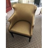 A Modern Wing Back Chair Upholstered In Gold Leather With Pin Stud Detail On Dark Solid Wood Frame