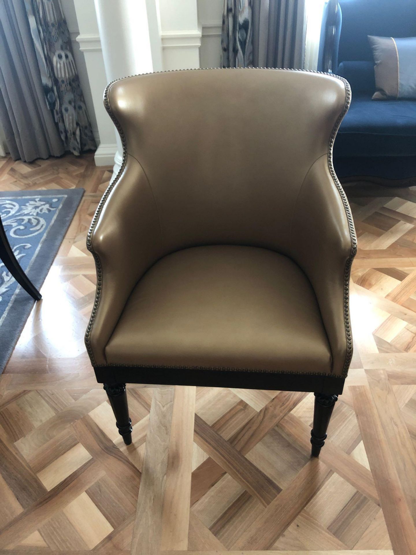 A Modern Wing Back Chair Upholstered In Gold Leather With Pin Stud Detail On Dark Solid Wood Frame