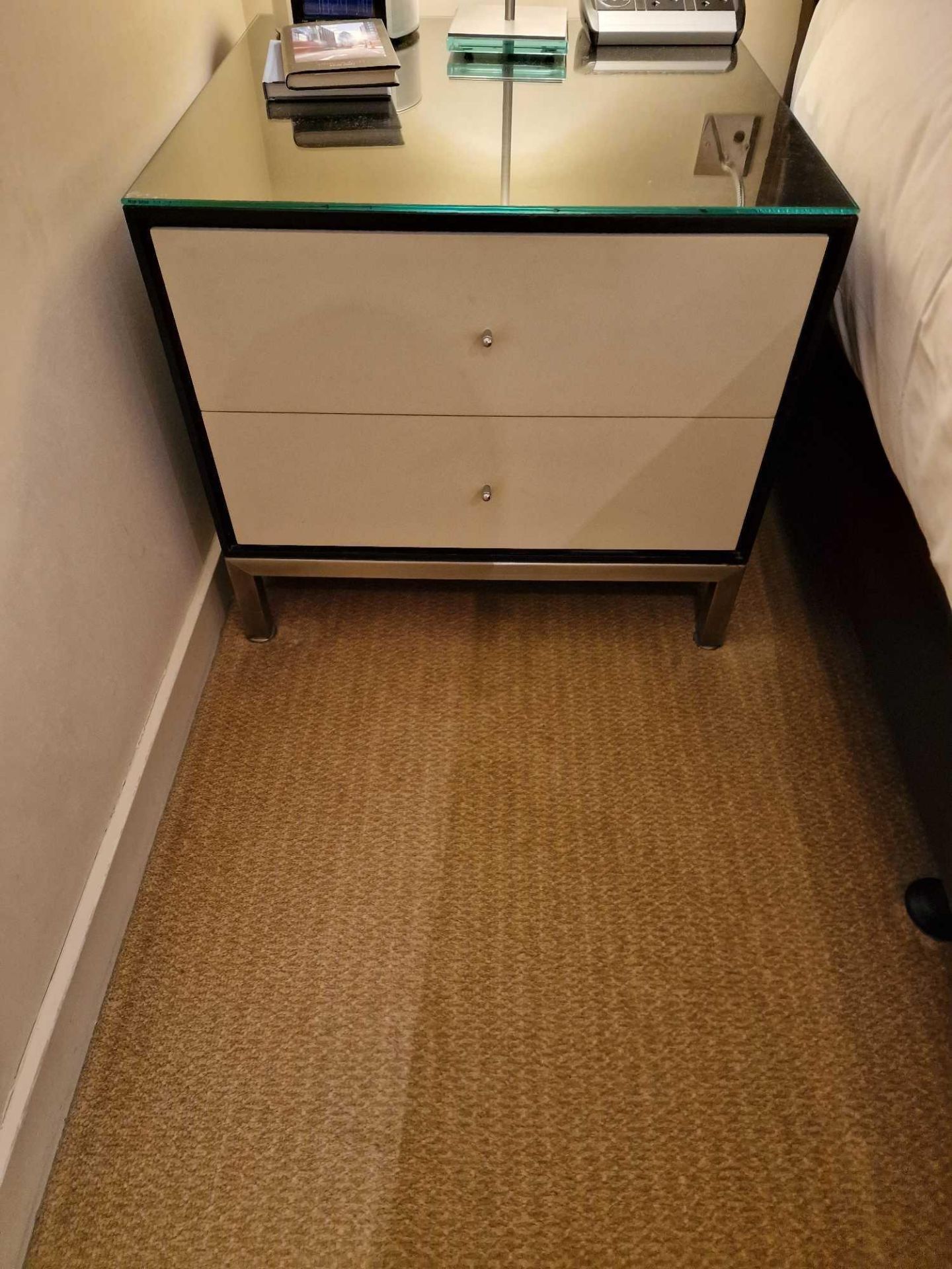 A pair of bedside cabinets by Benhardt black ash mounted glass protective top on stainless steel