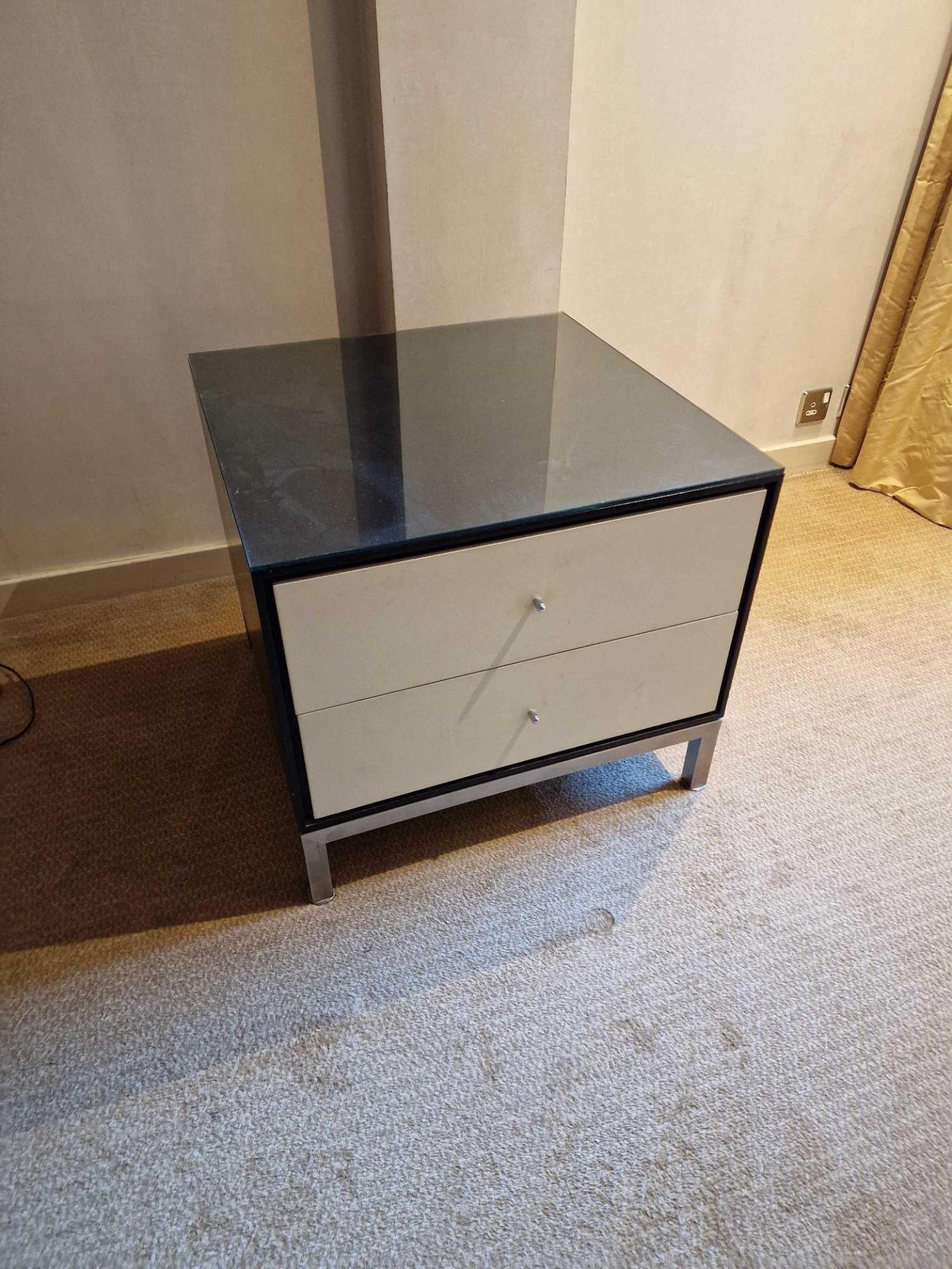 A pair of bedside cabinets by Benhardt black ash mounted glass protective top on stainless steel