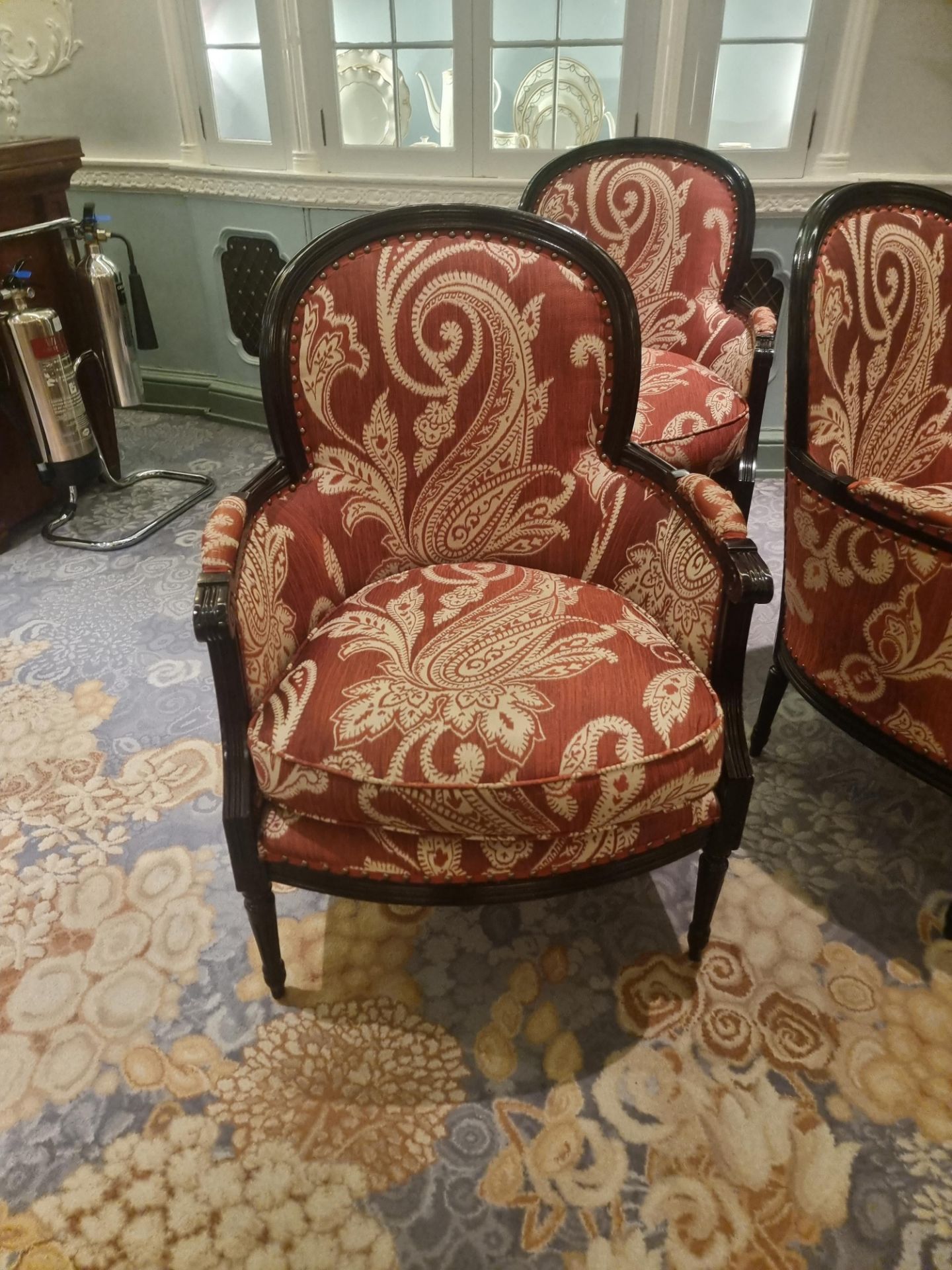 A Pair Of Bergere Chairs Black Wood Frame Upholstered In A Rust Red And Cream Damask Pattern With