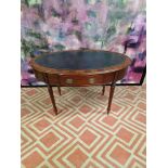 Oval writing table with blue tooled leather inlay under a protective glass top, the apron features