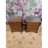 A pair of bedside cabinets with protective glass top the boxwood strung top above three drawers with