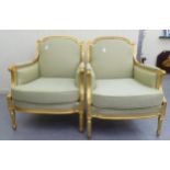 A Pair Of Louis XVI Style Antique Finished Gilded Show Wood Framed Enclosed Salon Chairs,