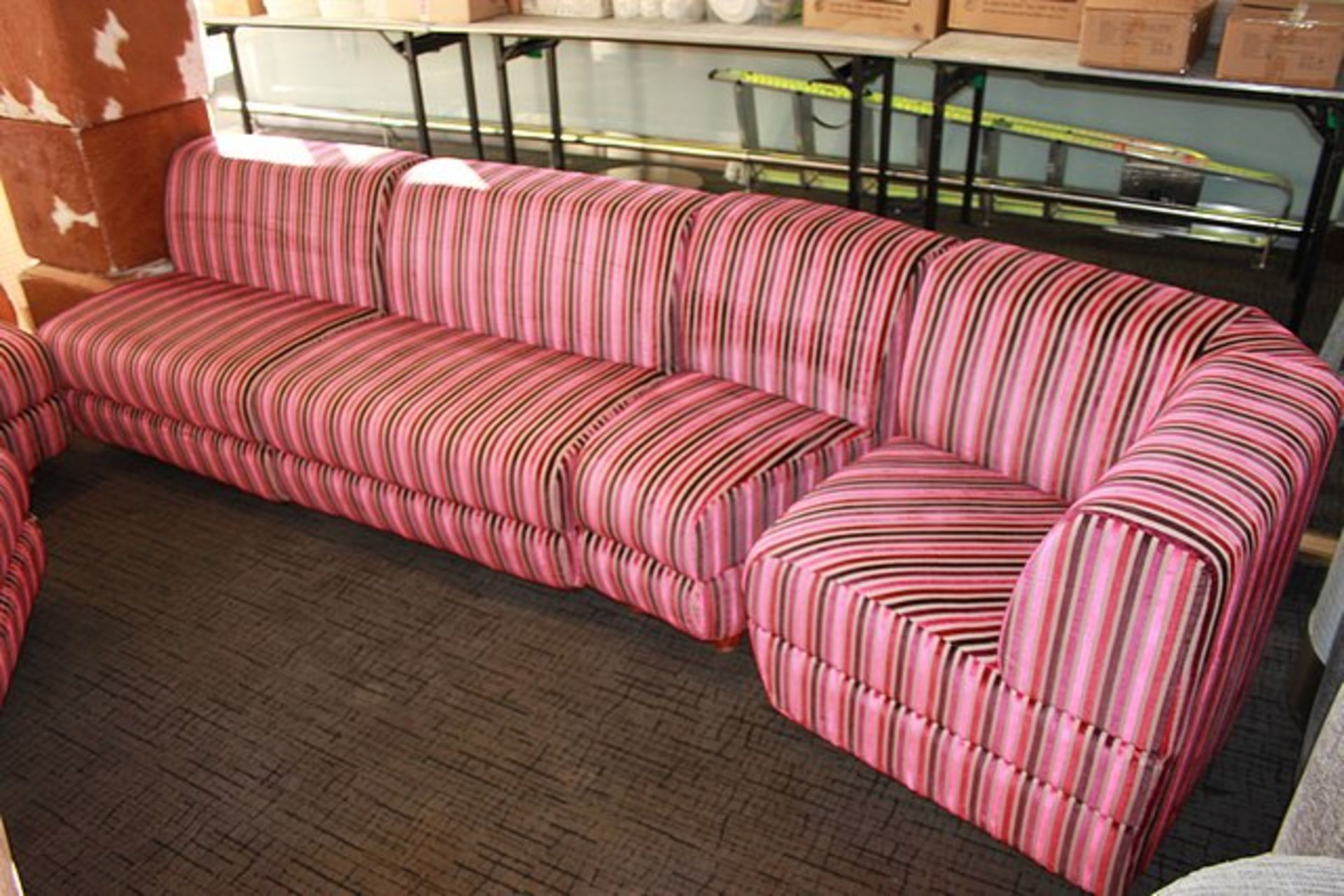 Sectional sofa comprising six pieces upholstered in a pink stipe material spans approximately 4m