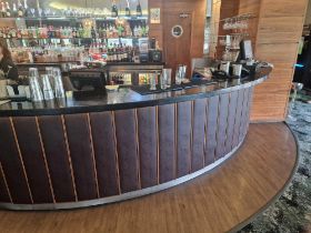 Bar counter with back bar system a wooden structured unit with black stone top with a faux leather